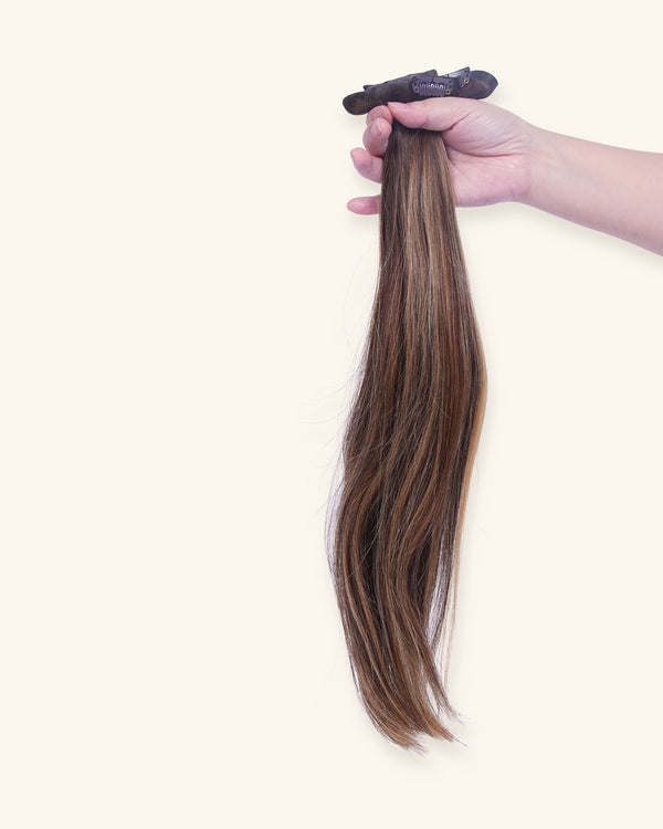 Set of 7 clip-in hair extensions, 22 inch balayage, held in hand